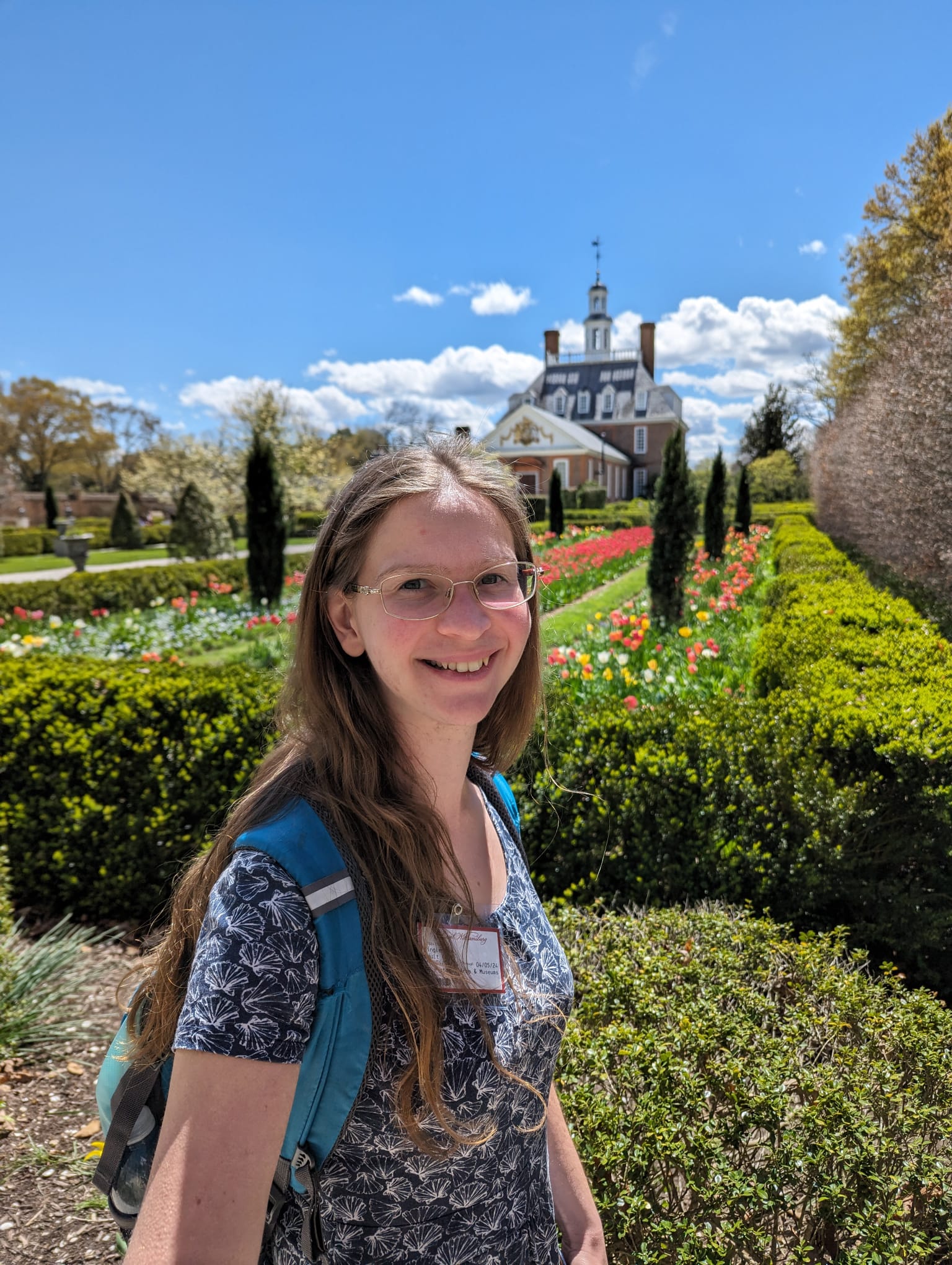 Mary Clayton Kastenholz in a garden in front of a large house