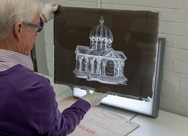 A man looking at a negative photograph of a church